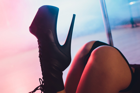 young striptease dancer moving in high heels shoes on stage in strip night club, Pole dancing.の写真素材