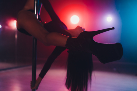 young striptease dancer moving in high heels shoes on stage in strip night club, Pole dancing.の写真素材