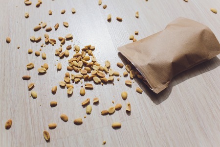 Spilled brown bag of peanuts in shells.の写真素材