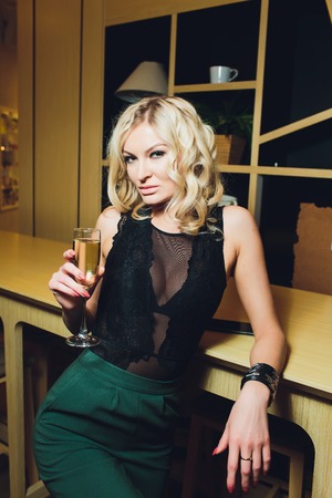 Beautiful woman with a glass of wine in an evening dress.の写真素材