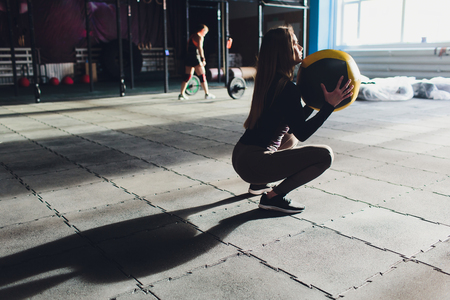 Beautiful young woman in fitness center doing pilates exercise with fitness ball. Healthy lifestyle concept.の写真素材