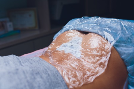 Cosmetologist with patient and professional tattoo removal laser in salon.の写真素材