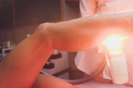 Medical beauty laser cosmeology procedure. Young female at salon. Professional doctor. Woman skincare technology. Hair removal.の写真素材