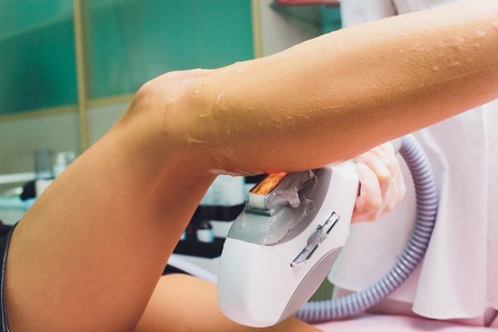 Medical beauty laser cosmeology procedure. Young female at salon. Professional doctor. Woman skincare technology. Hair removal.の写真素材