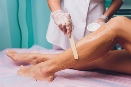 Applying a contact gel before the procedure of laser hair removal. Application of sugar paste for the procedure of shugaring.の写真素材