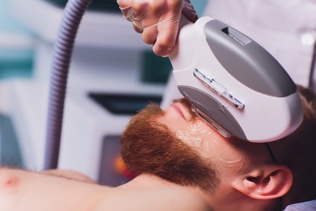 Young Man Receiving Laser Hair Removal Treatment At Beauty Center.の写真素材