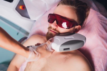 Young Man Receiving Laser Hair Removal Treatment At Beauty Center.の写真素材