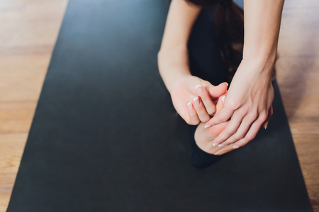 Young woman practicing yoga, stretching in variation of Reverse Table Top exercise, Bridge pose, working out, wearing white sportswear, indoor full length.の写真素材