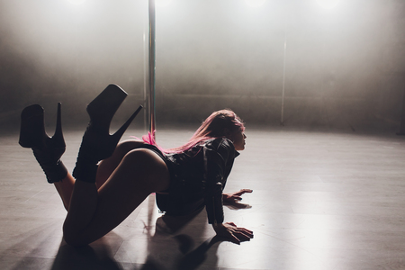 beautiful pole dancer in leather jacket on pylon.の写真素材