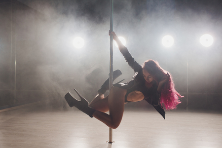 beautiful pole dancer in leather jacket on pylon.の写真素材