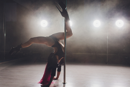 beautiful pole dancer in leather jacket on pylon.の写真素材
