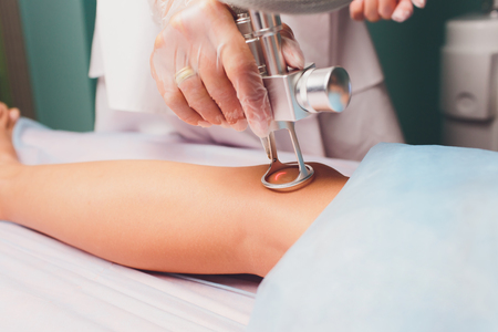 Medical beauty laser cosmeology procedure. Young female at salon. Professional doctor. Woman skincare technology. removal of the scar.の写真素材