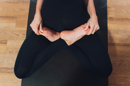 Young yogi attractive woman practicing yoga concept, standing in salamba sirsasana exercise, headstand pose, working out, wearing sportswear, black tank top and pants, full length, loft background. Advanced Fish poseの写真素材