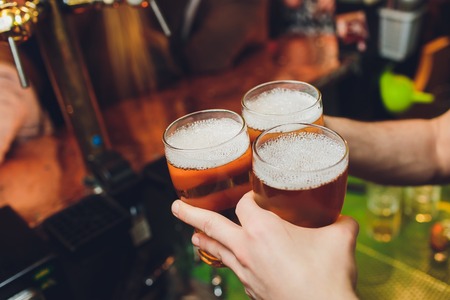 Closeup of Three Glasses of Beer Being Clinked.の写真素材