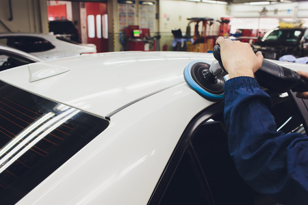 Car detailing - Hands with orbital polisher in auto repair shop. Selective focus.の写真素材