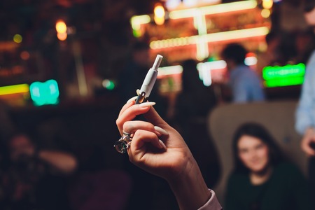 heat-not-burn tobacco product technology. Woman holding e-cigarette in his hand before smoking.