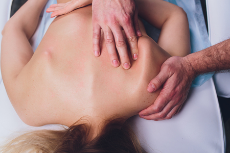 Young beautiful woman having massage in spa salon Physiotherapis.の写真素材