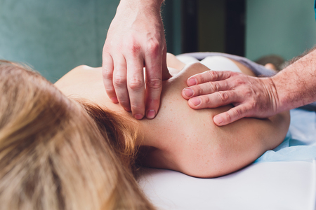 Young beautiful woman having massage in spa salon Physiotherapis.の写真素材