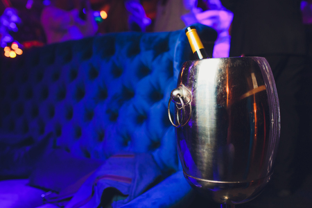 Bottle of wine in ice bucket on darck purple background.の写真素材