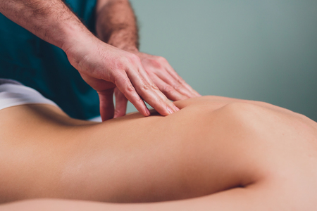 Young beautiful woman having massage in spa salon Physiotherapis.の写真素材
