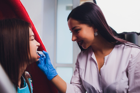 Dentist curing female patient Woman teeth examined at dentists teeth whitening. stomatology office Tooth care and tooth health. dentist working at her patients teeth.Teeth whitening procedure,choice.の写真素材