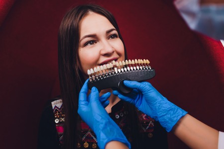 Dentist curing female patient Woman teeth examined at dentists teeth whitening. stomatology office Tooth care and tooth health. dentist working at her patients teeth.Teeth whitening procedure,choice.の写真素材