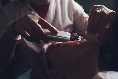 Hardware cosmetology. Beautician makes chromotherapy ultrasound cleaning the clients face. Skin pore cleansing. Anti-aging treatments. Spa. Non-invasive therapy.の写真素材