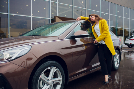 Portrait of chic young Brunettes with a sexual chest near the car.の写真素材
