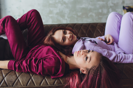 LGBT Cute young girls smiling and flirting on sofa at home.の写真素材