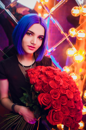 Portrait of a young beautiful woman smelling flowersの写真素材