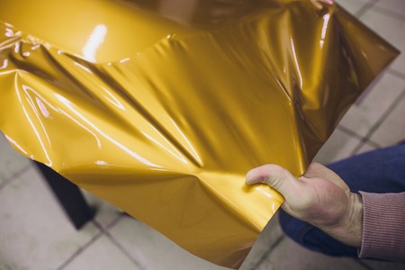 Car wrapping specialist putting vinyl foil or film on car wrapping protective film yacht, boat,...