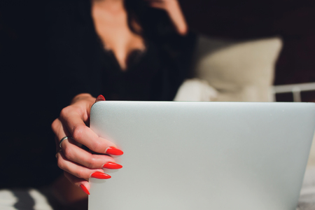 Beautiful, young girl posing in front of a web camera, working as a sexual model. The concept of online flirting, sex on the Internet.の写真素材