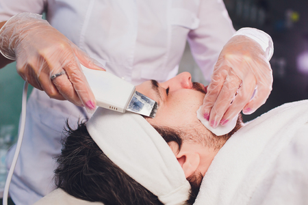 Ultrasonic face scrubber close up. Healthy young man, cosmetology.の写真素材