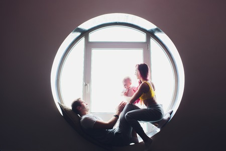 happy family of mother, father and child son playing and cuddling at home on floor near a big...