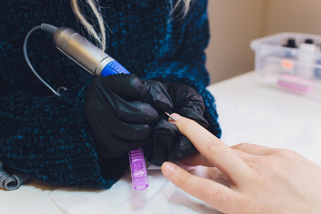 Hands in gloves cares about mans hand nails. Manicure beauty salon.の写真素材