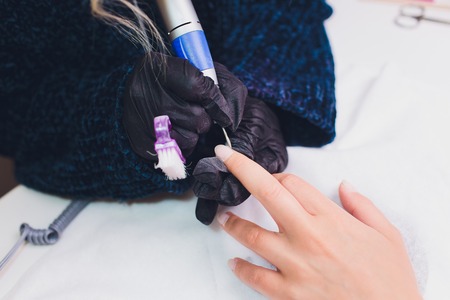Hands in gloves cares about mans hand nails. Manicure beauty salon.