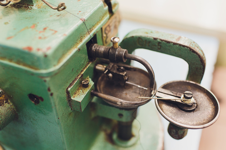 Professional sewing machine on the background of atelier studio. Workplace of tailor - sewing machine, rolls of thread, fabric, scissors. Sewing business concept.の写真素材