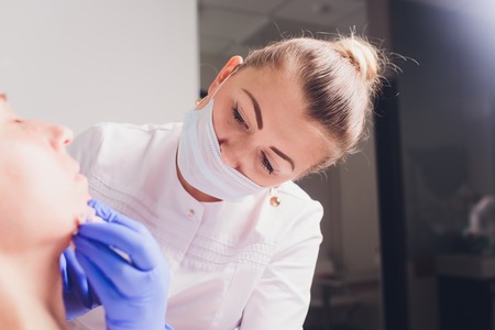 The doctor cosmetologist makes facial injections procedure for tightening and smoothing wrinkles on...