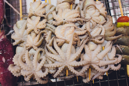 Freshly caught octopus vulgaris in a box with ice at the greek fish shop.の写真素材