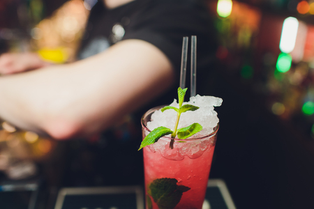 Refreshment alcoholic red cranberry and lime cocktail with rosemary and ice, two glass, dark background copy space.の写真素材