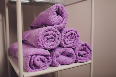 Stack of twisted terry towels on a shelf.の写真素材
