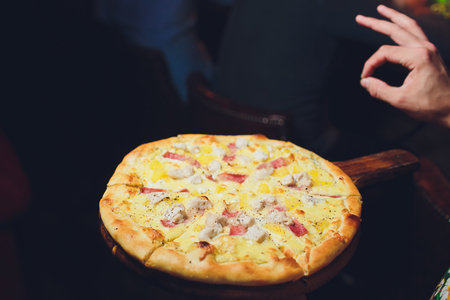 Close up of thin crispy pepperoni pizza and mozzarella cheese on black background.の写真素材