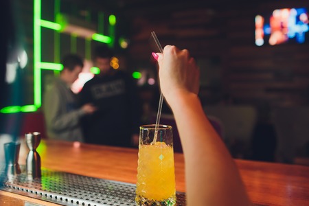 Fresh colorful exotic alcoholic cocktail with lemon mint and pomegranate in the bar. Tasty Soft drink with lemon, mint and pomegranate on the bar desk. Sex on the beach cocktail.の写真素材