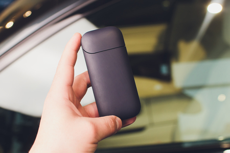 A heat-not-burn tobacco product technology.Man holding in one hand smoking module before smoking.