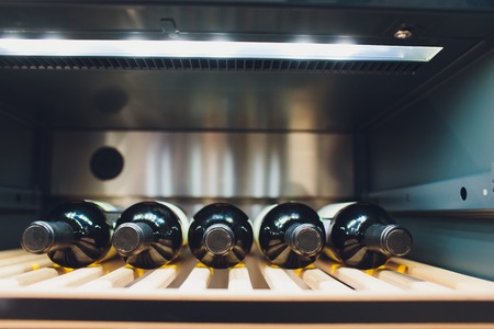 Storing bottles of wine in fridge. Alcoholic card in restaurant. Cooling and preserving wine.の写真素材