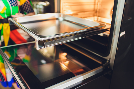 Empty open electric oven with hot air ventilation. New oven. Door is open and light is on.の写真素材
