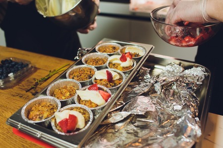 A chef decorates many plates of cake.の写真素材