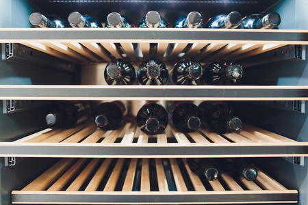 Storing bottles of wine in fridge. Alcoholic card in restaurant. Cooling and preserving wine.の写真素材