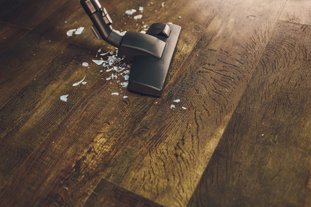 Dark head of a modern vacuum cleaner being used while vacuuming a rug. Cleaning service concept. Process carpet with vacuum cleaner.の写真素材