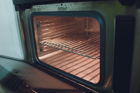 Empty open electric oven with hot air ventilation. New oven. Door is open and light is on.の写真素材